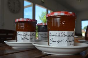 two jars of jam sitting on a plate on a table at Hôtel Land'Azur in Mimizan-Plage