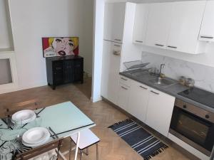 - une cuisine avec des placards blancs, une table et un évier dans l'établissement Superbe appartement Nice centre, à Nice