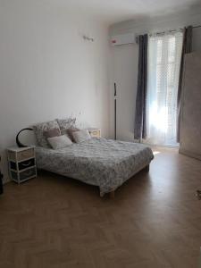 - une chambre blanche avec un lit et du parquet dans l'établissement Superbe appartement Nice centre, à Nice