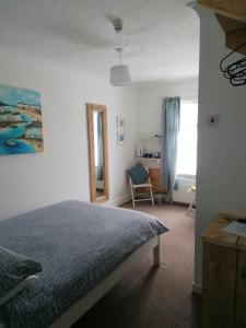 a bedroom with a bed and a desk and a window at Railway Cottage in Swanage