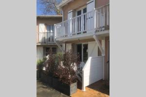 a large white house with a balcony at appartement residence avec piscine à anglet limite Biarritz in Anglet