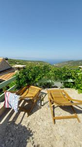 two chairs sitting on the sand near the ocean at Peacefull and Romantic Hillside House in Jelsa