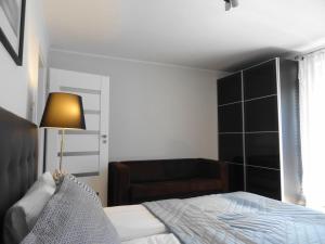 a bedroom with a bed and a lamp and a couch at Studio 5 min do Centrum Koneser, blisko dworzec Wschodni by VisitWarsaw in Warsaw