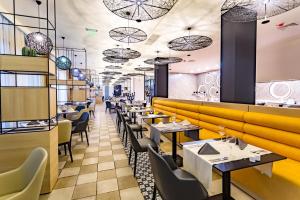 a restaurant with tables and chairs and a yellow wall at Barcelo Royal Beach Private Apartment in Sunny Beach