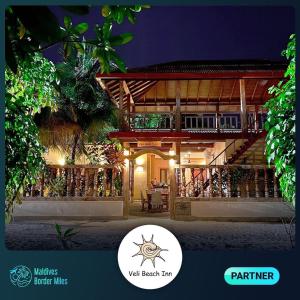 a picture of a villa at night with a sign that says warrior walk beach at Veli Beach Inn in Mathiveri