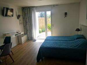 a bedroom with a bed and a sliding glass door at Hotel L'Ancre d'or in Pénestin