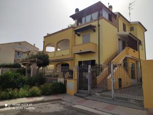 una casa amarilla con una valla delante en Casa Vacanze Pula, en Pula