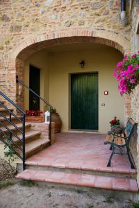a entrance to a house with a door and a bench at Il Sasso di San Galgano in Chiusdino