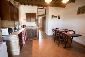 a kitchen with a counter and a table in it at Il Sasso di San Galgano in Chiusdino