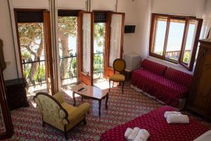 un soggiorno con divano, sedie e finestre di Villa Sarina ad Acciaroli