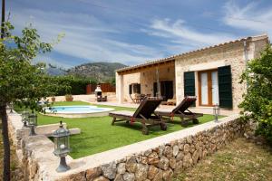 une maison en pierre avec une piscine et une cour dans l'établissement Finca Pou Monjo, à Caimari