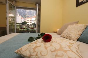 a red rose sitting on top of a bed at Villa Ivona in Makarska