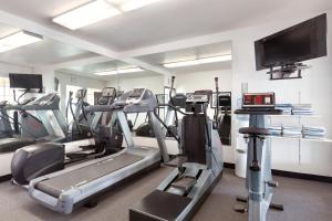 a gym with tread machines and a flat screen tv at Ramada by Wyndham Moses Lake in Moses Lake