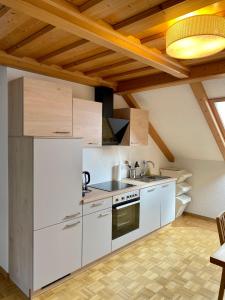 een keuken met witte apparatuur en een houten plafond bij Haus Sonnsitzer in Sommereben