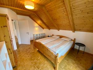 a bedroom with a bed in a room with wooden ceilings at Haus Sonnsitzer in Sommereben
