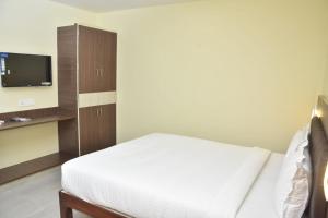 a bedroom with a bed and a flat screen tv at Le Arul Park in Karaikal +9 photos