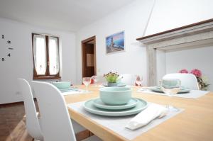 普埃尼亞戈的住宿－Corte Vezzola Trilocale Tommaso，用餐室配有带盘子和酒杯的桌子