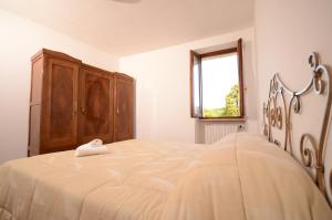 普埃尼亞戈的住宿－Corte Vezzola Trilocale Tommaso，一间卧室配有一张大床和木柜