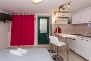 a kitchen with a red curtain and a red door at Modern and practical studio in the heart of Split in Split