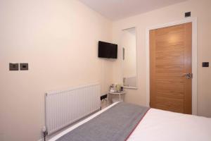 a bedroom with a bed and a wooden door at The Dakota Guesthouse Baginton in Baginton