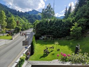 a green yard with flowers on the side of a road at Apartment Daum - Deine Ferienwohnung in Mühlbach am Hochkönig in Mühlbach am Hochkönig