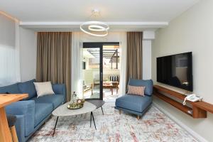 a living room with a blue couch and a tv at Luxury Aparthotel Zadar in Zadar