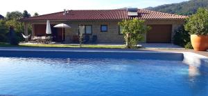 a house with a swimming pool in front of a house at Cottage, Casa do Laranjal - Near Gerês in Geres