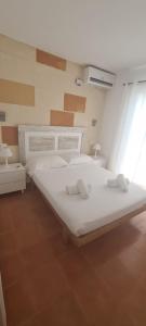a bedroom with a large white bed with two towels at Chalet tranquilo y acogedor a 50 metros de la playa in Cala Blanca
