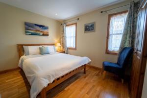 um quarto com uma cama e uma cadeira azul em Burnham View em Dingle