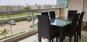 席迪拉罕的住宿－Appartement Ola Blanca 2，享有街景的带椅子的餐桌