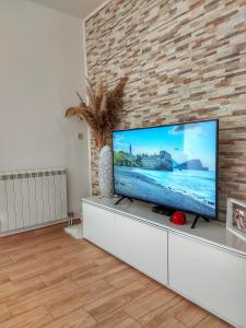 a living room with a large flat screen tv on a brick wall at Studios Merdović in Budva