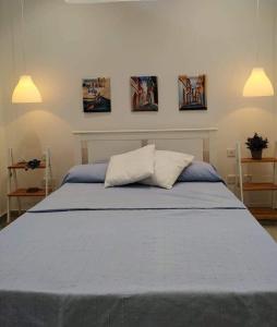 a bedroom with a blue bed with three pictures on the wall at Bayview in Pembroke 