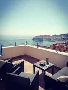 a balcony with chairs and a table and the ocean at Villa Ragusa in Dubrovnik