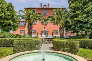 a mansion with a fountain in front of a building at Relais Pian Di Vico in Tuscania