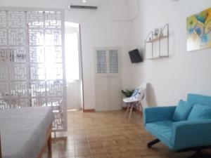 ein Wohnzimmer mit einem blauen Sofa und einem Tisch in der Unterkunft Casa Vacanze Mazzini in Santa Maria al Bagno