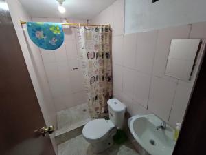 y baño con aseo, ducha y lavamanos. en Casa Vacacional en Baños de Agua Santa, en Baños