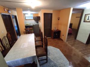 Zimmer mit einem Tisch und Stühlen sowie einer Küche in der Unterkunft Casa Vacacional en Baños de Agua Santa in Baños