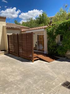 a house with a wooden fence in front of a patio at le Garden Cocoon in Istres