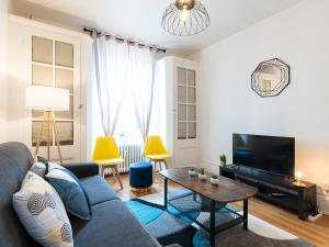 a living room with a blue couch and a table at LE DEDIEU - HYPERCENTRE GARAGE GRATUIT WiFi NETFLIX AMAZON PRIME in Villeurbanne