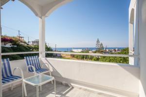 a balcony with two chairs and a view of the ocean at Grace Studios & Apartments in Sfakaki