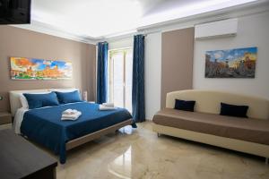 Un dormitorio con una cama azul y un sofá. en B&B Azul, en Palermo