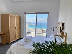 a bedroom with a bed with a view of the ocean at Villa Ioanna oliveproject in Plakias