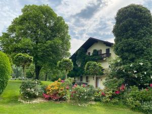 una casa bianca con fiori in un giardino di Am Lenzensberg 667 - Neu mit E-Ladestation a Traunstein