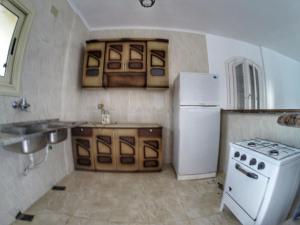 a kitchen with a stove and a white refrigerator at فيلا للايجار في الساحل الشمالي in Dawwār ‘Abd al ‘Aţī Abū ‘Ajūz