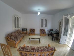 a living room with a couch and a table and chairs at فيلا للايجار في الساحل الشمالي in Dawwār ‘Abd al ‘Aţī Abū ‘Ajūz