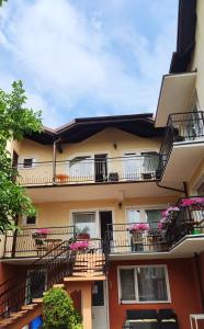 an apartment building with balconies and flowers at Pokoje Gościnne u MARCINA- sala zabaw, basen, melex, rowery, grill in Ostrowo