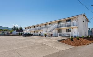 a building with a car parked in a parking lot at Sundowner Motel Sequim in Sequim