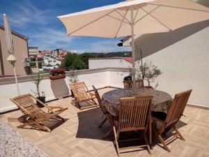 a patio with a table and chairs and an umbrella at Appartements Dominique, with private terrace in Supetarska Draga