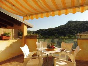 een tafel en stoelen op een balkon met uitzicht bij Grazioso attico vicino alla spiaggia e al centro in Castelsardo