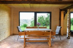 una sala da pranzo in legno con tavolo e sedie di Rustic retreat with pool počitnice na kozolcu a Sevnica